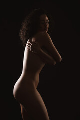 Fototapeta premium Beautiful nude woman posing on black background