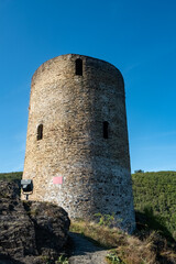 Esch-sur-Sure, Wiltz, Grand-Duche de Luxembourg, September 07, 2025, Lone hiker explores textured fortress on rugged trail, Jagged basalt and ancient masonry under dramatic sunset shadows