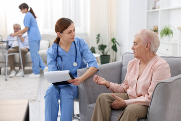 Obraz premium Care worker asking senior woman about her wellbeing at retirement home