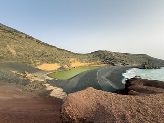 Lava landscape with green lagoon and ocean view.. Lanzarote, Canary Islands, Spain