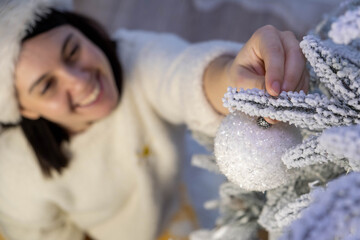 Woman Decorating Snowy Christmas Tree with Ornament Copy Space
