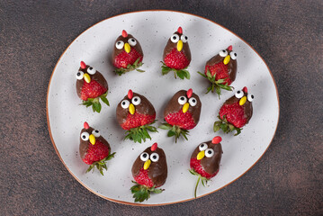 Strawberries in chocolate in shape of birds, Culinary idea for kids party, Top view