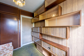 Old Soviet Retro Styled Home Living Room Interior With Floral Sofa and Wooden Shelving Units