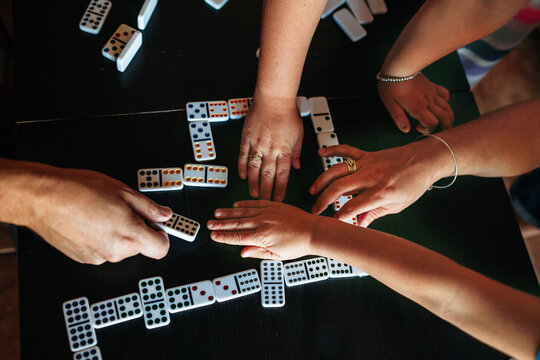 hands playing dominoes game