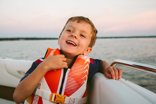 little boy in boat with life vest 