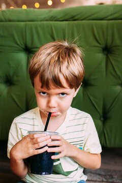 boy drinking with a pout