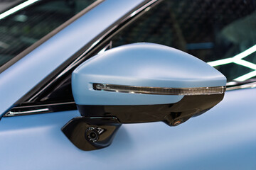 Car side mirror with integrated camera blue car, cam for driver safety and visibility. Car side view camera system integrated into rearview mirror, blind spot detection, 360 visibility. Camera 360. 