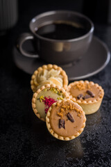 Sweet mini tartlets on black table.
