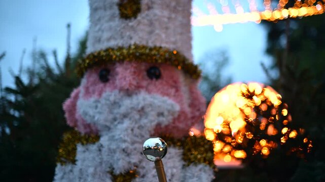 Christmas nutcracker soldier decoration illuminated by festive string lights at dusk