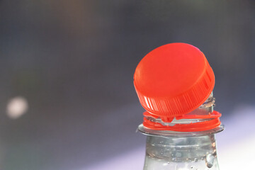 Bottle with orange cap sitting on table indoors during daytime