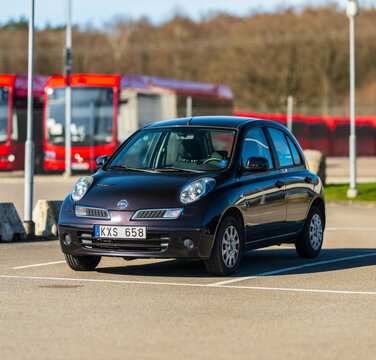 Gothenburg, Sweden - April 10 2025: Compact 2005 Nissan Micra parked near urban transit.
