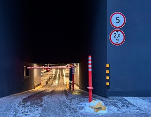 lighted underground parking lot in a residential building or shopping center, signs and barrier