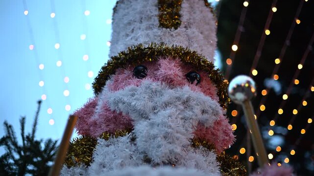 Decorative Christmas nutcracker soldier figure displayed outdoors with trees in the background