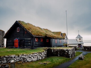 Old Harbor Dwellings With Colorful Accents, Coastal Village Featuring Mosscovered Walls And Cloudy Skies