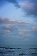 Obraz premium Ocean waves washing dark sand beach at dusk