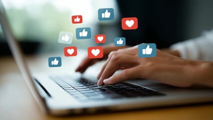 Close-up of hands typing on a laptop keyboard with floating social media icons showing likes, comments, and followers. The scene represents online engagement, digital communication  4K - Powered by Adobe