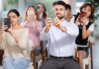 Students scan QR code and use their phone to connect to schools online group. Lecture room is filled with listeners. Company managers during training, professional development courses