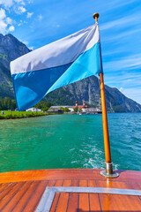 Bootsfahrt auf dem K&ouml;nigssee mit Blick auf die ber&uuml;hmte Wallfahrtskirche St. Bartholom&auml; und der bayerischen Fahne. In Deutschland, Bayern