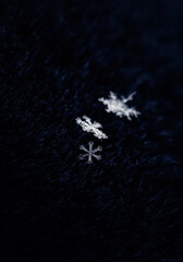 beautiful shiny carved cold snowflakes lie on blue fur in winter garden