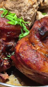 pork knuckle with potatoes Pork knuckle. Schweinshaxe. Seamless Loop. It has a ruddy, golden-brown crust. The meat inside is tender and juicy. On the plate. Potato dumplings. Sauerkraut. Fresh herbs. 