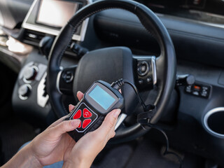 Woman using OBD2 diagnostic scanner. 