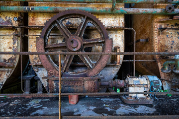 Vintage machinery inside an abandoned sugar refinery in Italy. Rusted equipment and industrial...