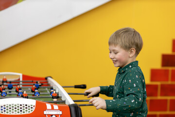 Boy playing table football in kids entertainment center