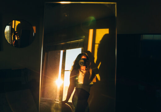 woman in bedroom taking photo of herself