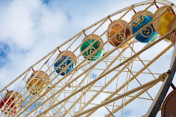 Colorful ferris wheel against blue sky at amusement park