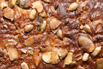 Dark whole grain bread crust with seeds. Healthy artisan loaf surface macro. Baked rye wheat bread texture closeup. Homemade multigrain bread with sunflower pumpkin seeds. Rustic bakery detail.