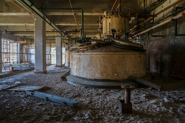 Derelict industrial hall of an abandoned Italian sugar mill. Large warehouse ruins with decaying...