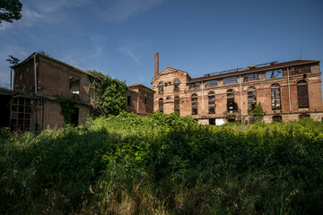 Obraz premium Abandoned sugar factory interior in Italy. Industrial urbex photography of derelict refinery ruins with rusted machinery and old architecture