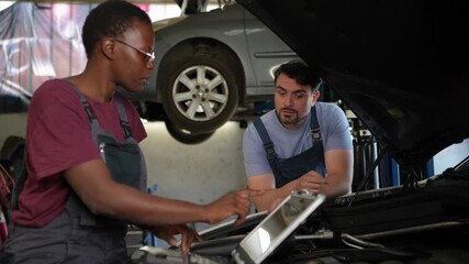 Mechanics check car engine at repair shop in the afternoon