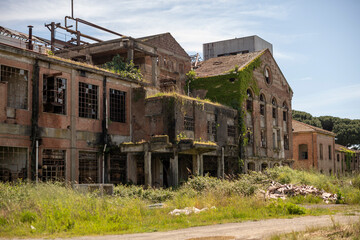 Fototapeta premium Abandoned sugar factory interior in Italy. Industrial urbex photography of derelict refinery ruins with rusted machinery and old architecture