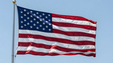 Obraz premium American flag waving gently against a clear blue sky on a bright sunny day
