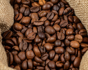 Close up of roasted brown coffee beans in a burlap sack