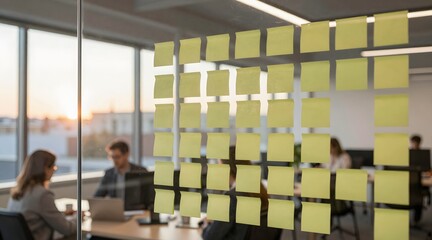 Sticky notes adorn glass wall in modern office space during golden hour