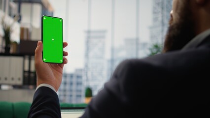 Young entrepreneur in a corporate office space monitors market conditions, setting strategic financial goals and making leadership decisions for long term profitability. Work ethic. Camera A.