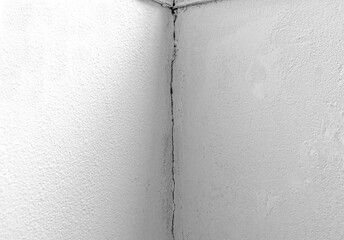 White concrete wall broken corner cracked damage stucco building. Filler wall failed fixing repair. Unfinished work.