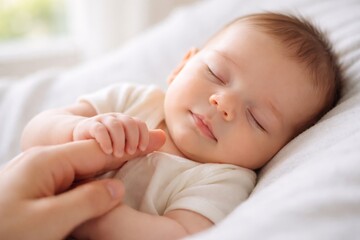 A serene sleeping baby, peacefully resting in soft morning light, with a gentle touch from a parent's hand.