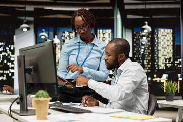 African american business partners analyzing data insights meeting in office, consulting the analysis forecast before developing a new strategy for the enterprise activity after hours.