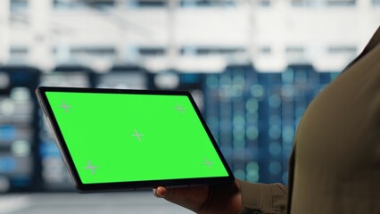 Server room admin uses isolated screen tablet to increase supercomputers workload capacity. Data center worker configures gear with chroma key device notebook, improving processing speed, camera B