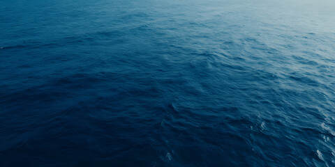 A serene and vast ocean scene with turbulent waves and textured water, set against a clean white background.