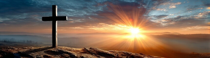 Wooden Cross Silhouette on a Hill with Dramatic Sunrise and Misty Landscape Background