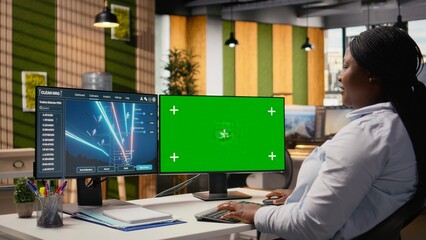 Engineer looks at power lines analytics dashboard on isolated screen PC showing metrics. African american woman uses mockup computer in office used to analyze transmission tower sensor data, camera A
