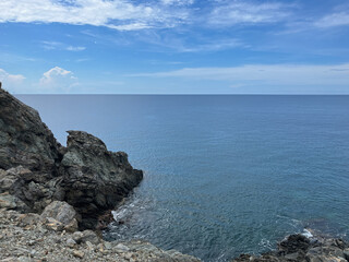  Rocky coastline with dark jagged cliffs and deep blue ocean horizon