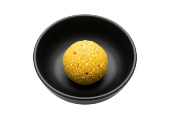 golden sesame laddoo in black bowl, ramadan eid mubarak