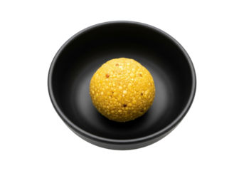 golden sesame laddoo in black bowl, ramadan eid mubarak