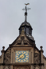 Beautiful blue clock with gold elements on the roof of the building.