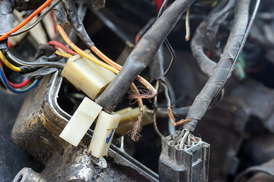 damaged, dirty, and messy electrical cables and connectors from an old motorbike. a mess of poor maintenance and repairs
